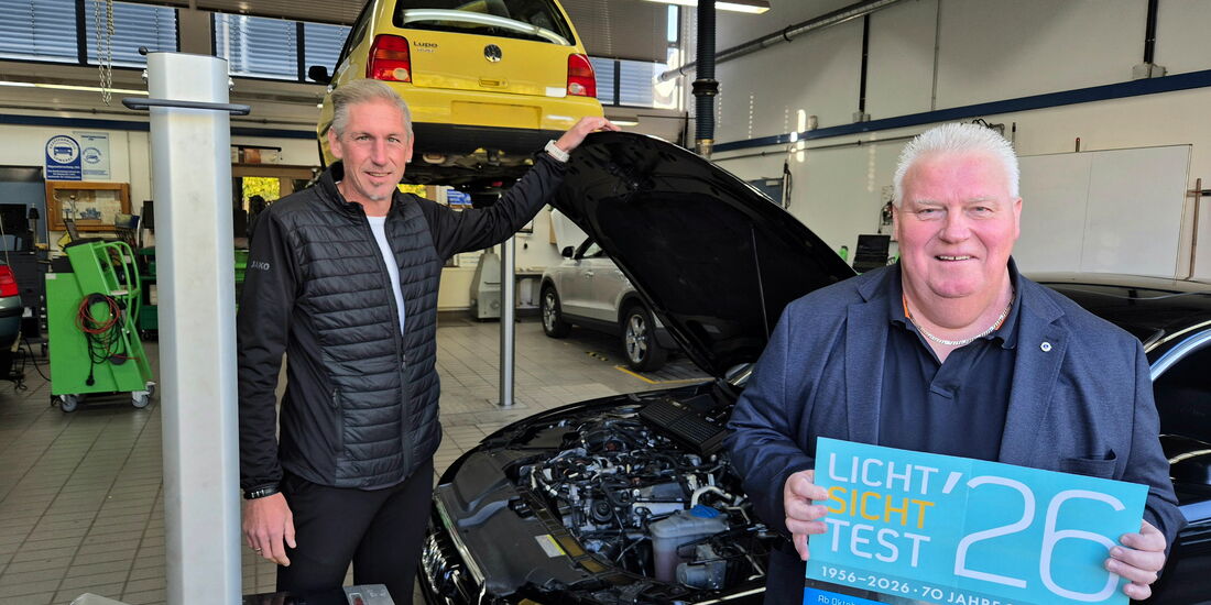 Fritz Faupel und Kai Bremmer stehen mit einem Auto und Prüfgerät in der Kfz-Werkstatt beim Licht-Sicht-Test.